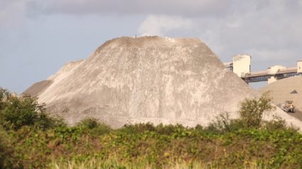 Puerto Ricans in Guayama say particles from this 120-foot high mound of coal ash mixed with water covers their homes and may be the cause of elevated public health issues. Photo by PBS NewsHour Weekend