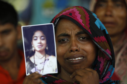 A woman holds a picture of her relative, a garment worker who went missing in the Rana Plaza collapse in Savar, Bangladesh, a year after the accident on April 24, 2014. Photo by Andrew Biraj/Reuters
