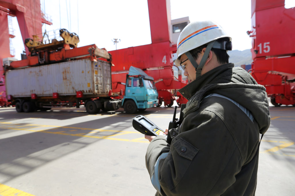 A worker verifies serial numbers on shipping containers at a port in Lianyungang, Jiangsu province, China April 6, 2018. P...