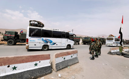 A bus carries rebels and their families who left Douma, at the entrance of the Wafideen camp in Damascus, Syria. Photo by Omar Sanadiki/Reuters