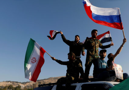 Syrians wave Iranian, Russian and Syrian flags during a protest against U.S.-led air strikes in Damascus on April 14. Photo by Omar Sanadiki/Reuters