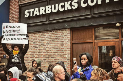 Tsehaitu Abye holds up a banner as people demonstrate outside a Starbucks cafe in Philadelphia, Pennsylvania, in this picture obtained from social media. Photo by @JILLIANPHL/Twitter via Reuters