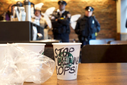 A Starbucks coffee cup with "Stop Calling Cops!" written on the side sits on a table as police monitor protesters demonstrating inside a Center City Starbucks, where two black men were arrested, in Philadelphia, Pennsylvania. Photo by Mark Makela/Reuters