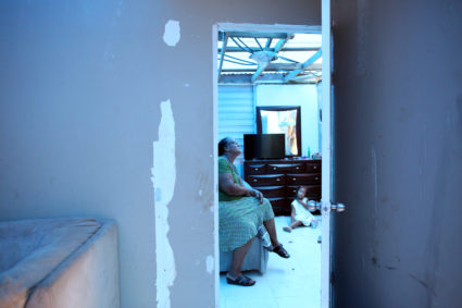 Milagros Nolazco sits in her bedroom and near her granddaughter Isya, as a plastic sheet replaces the roof hit by Hurricane Maria in September, in a neighbourhood in Canovanas, Puerto Rico April 10, 2018. REUTERS/Alvin Baez - RC1C2825E310