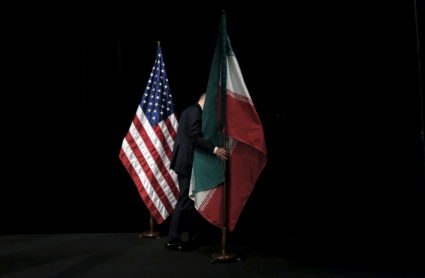 A staff member removes the Iranian flag from the stage after a group picture with foreign ministers and representatives of Unites States, Iran, China, Russia, Britain, Germany, France and the European Union during the Iran nuclear talks at the Vienna International Center in Vienna, Austria July 14, 2015. Iran and six major world powers reached a nuclear deal on Tuesday, capping more than a decade of on-off negotiations with an agreement that could potentially transform the Middle East, and which Israel called an "historic surrender". REUTERS/Carlos Barria