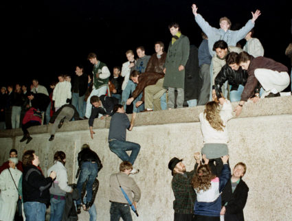 East German citizens climb the Berlin wall at the Brandenburg Gate as they celebrate the opening of the East German border in this November 10, 1989 file photo. Photo by Reuters stringer