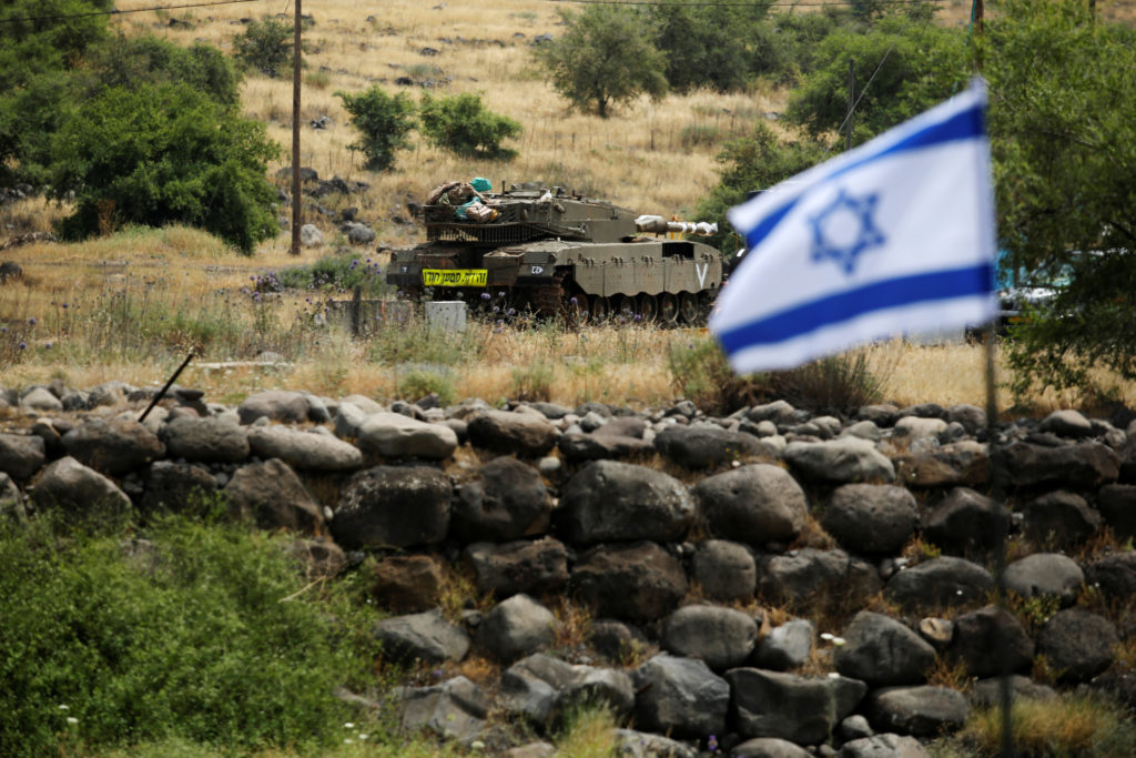 An Israeli tank can be seen near the Israeli side of the border with Syria in the Israeli-occupied Golan Heights, Israel. Photo by Amir Cohen/Reuters