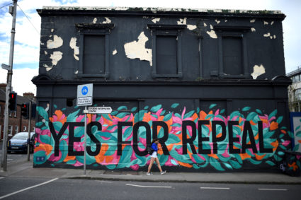 A woman walks past a pro-choice mural on the side of a building ahead of a 25th May referendum on abortion law, in Dun Laoghaire, Ireland. Photo by Clodagh Kilcoyne/Reuters