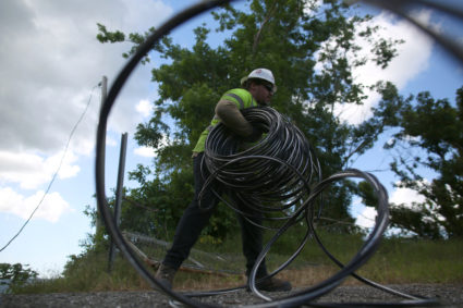A contractor of the U.S. Army Corps of Engineers carries cables as the island's fragile power system is still reeling from the devastation wrought by Hurricane Maria eight months ago, in Utuado, Puerto Rico May 17, 2018. Photo by Alvin Baez/Reuters