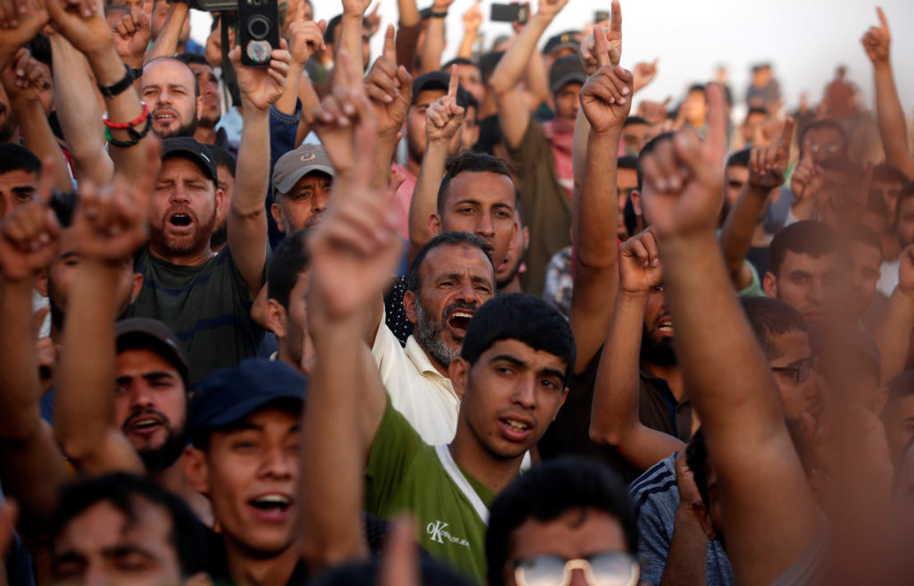 Palestinian demonstrators chant slogans during a protest demanding the right to return to their homeland, at the Israel-Ga...