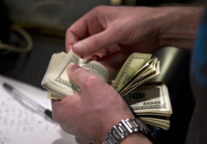 A man counts out $100 bills as he makes a bet on Super Bowl XLVIII at the Las Vegas Hotel & Casino Superbook in Las Vegas, Nevada. Photo by Steve Marcus/Las Vegas Sun/Reuters