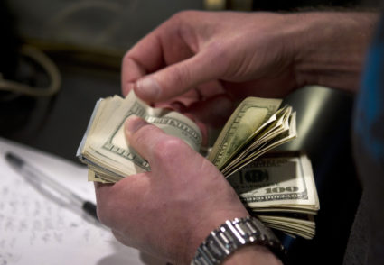 A man counts out $100 bills as he makes a bet on Super Bowl XLVIII at the Las Vegas Hotel & Casino Superbook in Las Vegas, Nevada. Photo by Steve Marcus/Las Vegas Sun/Reuters