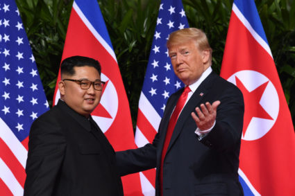 US President Donald Trump (R) gestures as he meets with North Korea's leader Kim Jong Un (L) at the start of their historic US-North Korea summit, at the Capella Hotel on Sentosa island in Singapore on June 12, 2018. - Donald Trump and Kim Jong Un have become on June 12 the first sitting US and North Korean leaders to meet, shake hands and negotiate to end a decades-old nuclear stand-off. (Photo by SAUL LOEB / AFP/Getty Images)