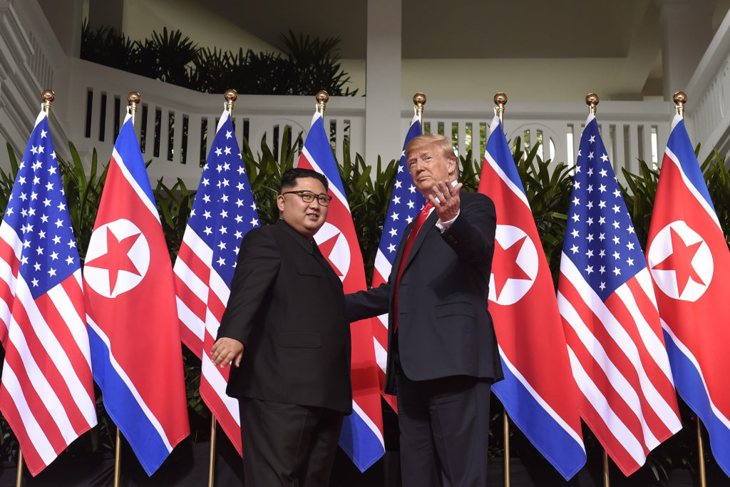 President Donald Trump gestures as he meets with North Korea's leader Kim Jong Un at the start of their US-North Korea sum...