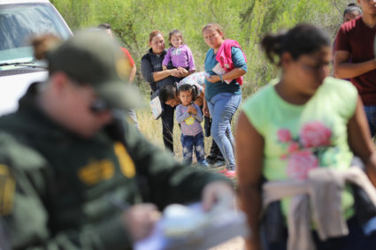 Central American asylum seekers wait as U.S. Border Patrol agents take them into custody on June 12, near McAllen, Texas. Photo by John Moore/Getty Images