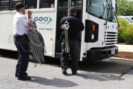 Men carry shackles to put on undocumented immigrants following hearings at a U.S. federal court in McAllen