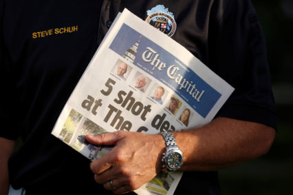 Steve Schuh, the County Executive of Anne Arundel County, Maryland, holds a copy of the Capital Gazette as he is interviewed the day after a gunman killed five people and injured two others at the newspaper's offices, in Annapolis, Maryland. Photo by Joshua Roberts/Reuters