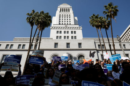 People hold signs to protest against President Donald Trump's executive order to detain children crossing the southern U.S. border and separating families outside of City Hall in Los Angeles, California. Photo by Patrick T. Fallon/Reuters