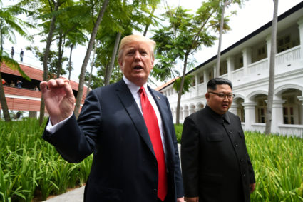 President Donald Trump gestures as he walks with North Korean leader Kim Jong Un in the Capella Hotel after their working lunch, on Sentosa island in Singapore. Photo by Anthony Wallace/Reuters