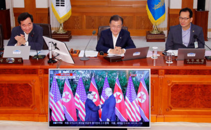 South Korean President Moon Jae-in looks at a TV broadcasting a news report on summit between the U.S. and North Korea during a cabinet meeting at the Presidential Blue House in Seoul, South Korea. Photo by Yonhap via Reuters