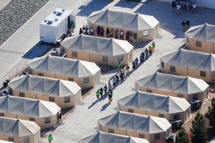 Immigrant children housed in a tent encampment, shown walking in single file at the facility near the Mexican border in Tornillo, Texas, on June 19, 2018. Photo by Mike Blake/Reuters