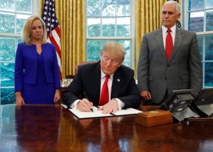U.S. President Donald Trump signs an executive order on immigration policy with DHS Secretary Kirstjen Nielsen and Vice President Mike Pence at his sides in the Oval Office at the White House in Washington, U.S., June 20, 2018. Leah Millis/Reuters