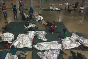 Children rest under mylar blanket at an immigrant housing facility in McAllen, Texas. Photo handout from U.S. Customs and Border Protection.