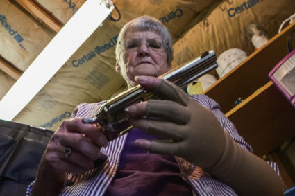 Dee Hill examines the last of the guns that once belonged to her husband, Darrell Hill. “I no longer have any guns in my home,” she says. Photo by Frank Carlson/PBS NewsHour