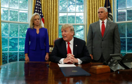President Donald Trump sits at this desk in the Oval Office with DHS Secretary Kristin Nielsen and Vice President Mike Pence prior to signing an executive order on immigration policy at the White House in Washington, U.S., June 20, 2018. REUTERS/Leah Milllis