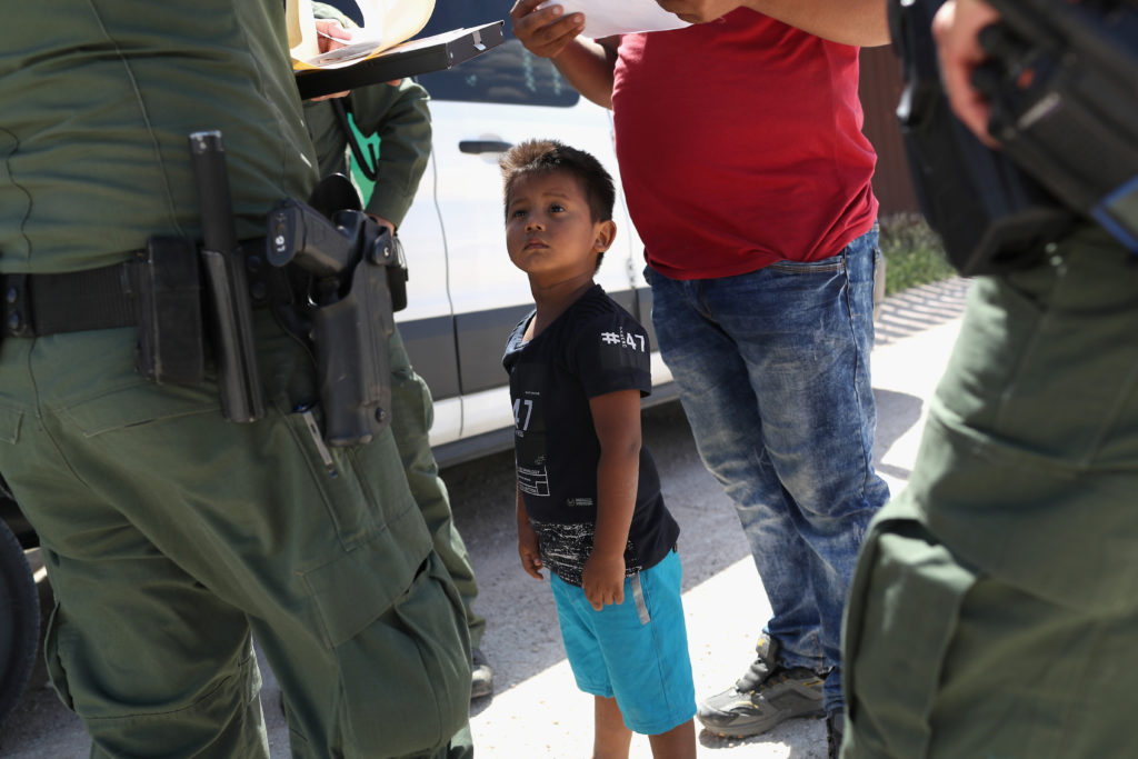 A boy and father from Honduras are taken into custody by U.S. Border Patrol agents near the U.S.-Mexico Border on June 12,...