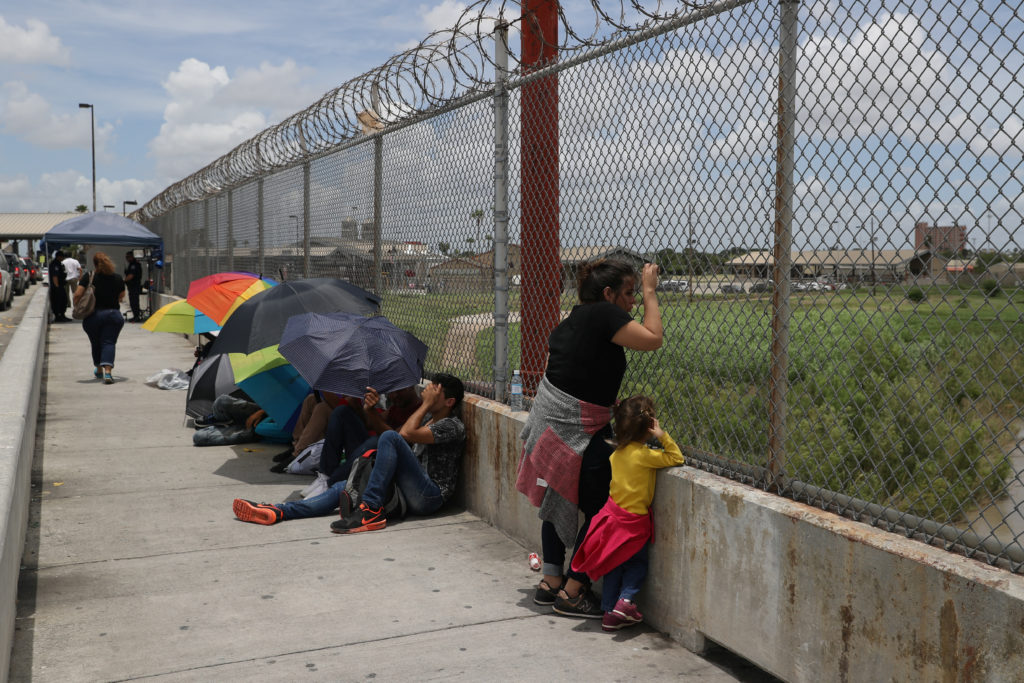 A Honduran mother and her 3-year-old daughter wait with fellow asylum seekers on the Mexican side of the Brownsville-Matam...