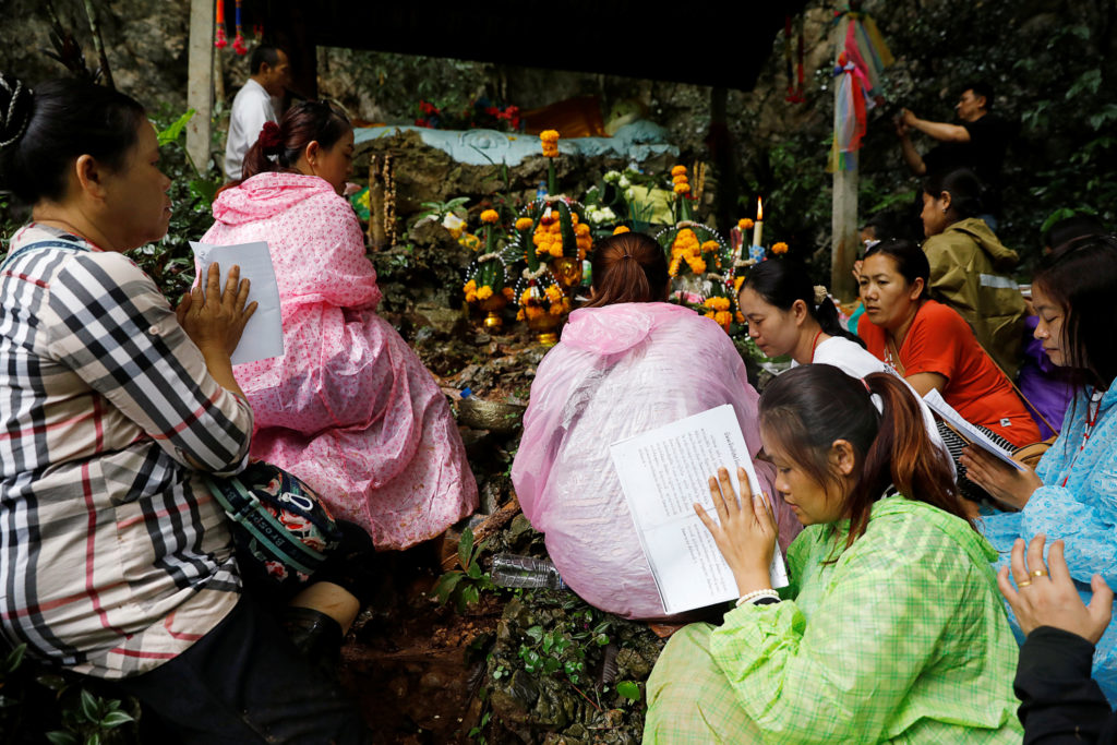 Family members pray near the Tham Luang cave complex during a search for members of an under-16 soccer team and their coach, in the northern province of Chiang Rai, Thailand, June 27, 2018. Photo by Soe Zeya Tun/Reuters