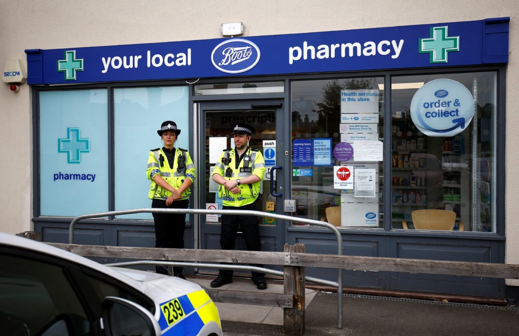 Police officers guard outside a branch of Boots pharmacy, which has been cordoned off after two people were hospitalized a...