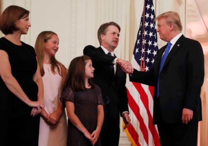 President Donald Trump shakes hands with Supreme Court nominee Judge Brett Kavanaugh as his wife Ashley Estes Kavanaugh and their two daughters look on at the White House on July 9. Photo by Leah Millis/Reuters