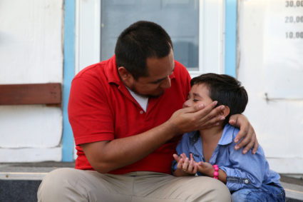 Walter Armando Jimenez Melendez, an asylum seeker from El Salvador, arrives with his four year-old son Jeremy at La Posada Providencia shelter in San Benito, Texas, U.S., shortly after he said they were reunited following separation since late May while in detention, on July 10. Photo by Loren Elliott/Reuters