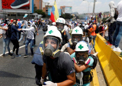 Volunteer members of a primary care response team huddle together during clashes with security forces at a rally against Venezuela's President Nicolas Maduro in Caracas, Venezuela, on April 26, 2017. Photo by Carlos Garcia Rawlins/Reuters