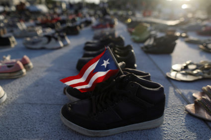 A Puerto Rican flag is seen on a pair of shoes as hundreds of pairs of shoes displayed at the Capitol to pay tribute to Hurricane Maria's victims after a research team led by Harvard University estimated that 4,645 people lost their lives, a number not confirmed by the government, in San Juan, Puerto Rico June 1, 2018. REUTERS/Alvin Baez - RC131BFE7FC0