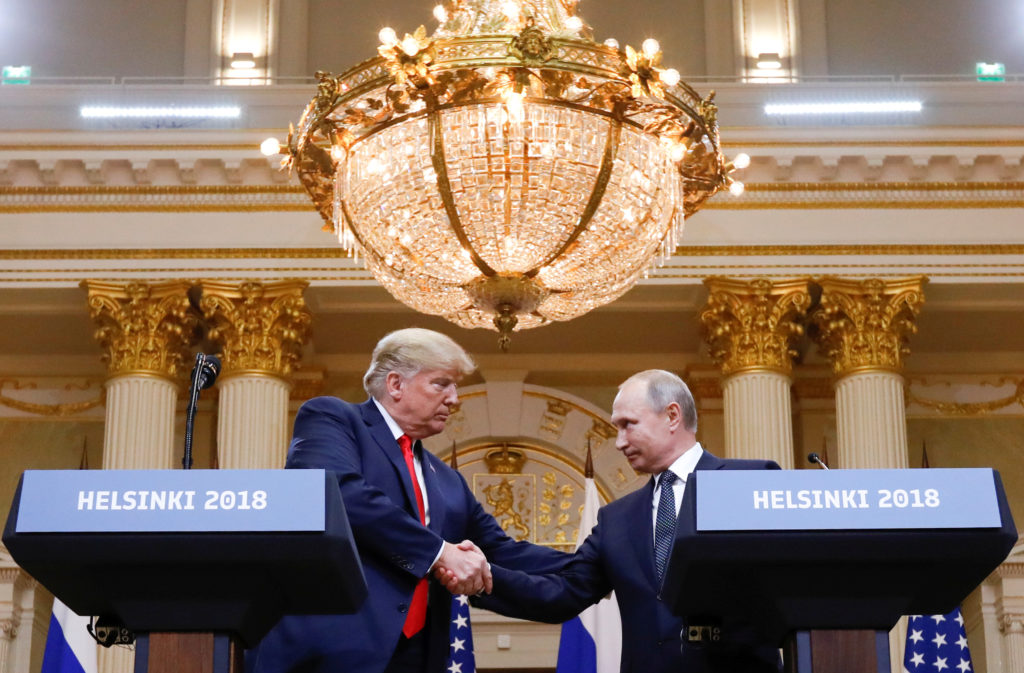 President Donald Trump and Russia's President Vladimir Putin shake hands during a joint news conference after their meetin...