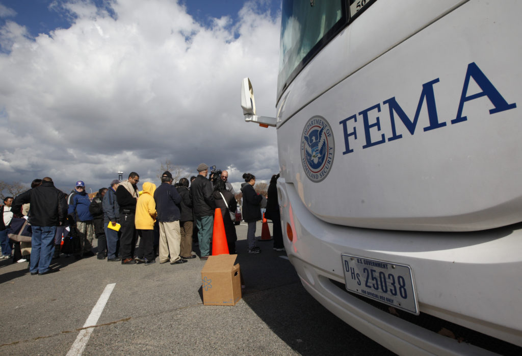 People wait in line to meet with FEMA officials in Coney Island, New York, November 2, 2012. Four days after Sandy smashed...