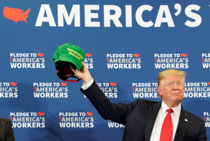 President Donald Trump holds up a "Make Our Farmers Great Again" cap during a roundtable discussion on workforce development at Northeast Iowa Community College in Peosta, Iowa, U.S., July 26, 2018. REUTERS/Joshua Roberts