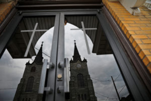Divine Redeemer Catholic Church is reflected off another church across the street in Mt. Carmel, Pennsylvania. The church was one of the locations where a priest accused of sexual abuse had been assigned. Photo by Carlos Barria/Reuters