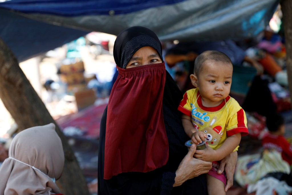 A villager holds her child at a temporary shelter on Aug. 6 after an earthquake hit Lombok island in Indonesia. Photo by B...