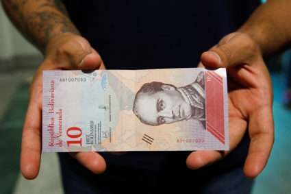 A man shows a new sovereign bolivar bill in Caracas, Venezuela on Aug. 20. Photo by Carlos Garcia Rawlins/Reuters