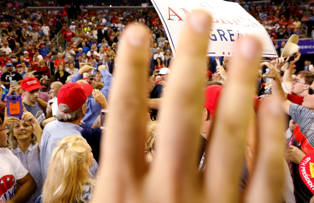 A volunteer attempts to block the view of protesters as U.S. President Donald Trump holds a "Make America Great Again" ral...