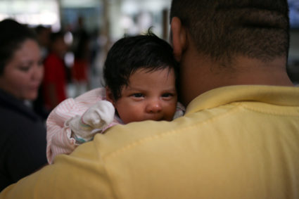 An undocumented immigrant father from Honduras and his infant daughter are released from detention with other families at a bus depot in McAllen, Texas. Photo by Loren Elliott/Reuters