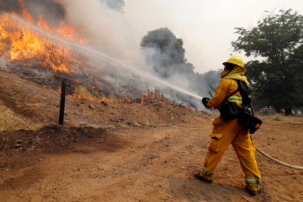 A firefighter uses a hose to knock down flames while battling the Ranch Fire (Mendocino Complex) north of Upper Lake, California, U.S., August 1, 2018. Photo by Fred Greaves/Reuters