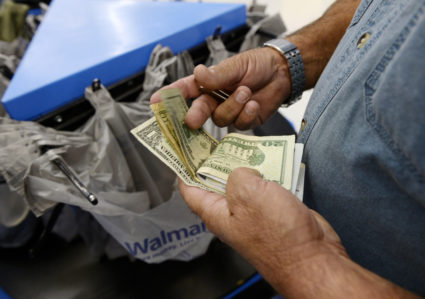 A customer counts his cash at the checkout lane of a Walmart store in the Porter Ranch section of Los Angeles. REUTERS/Kevork Djansezian