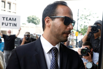 A protester holds a banner as former Trump campaign aide George Papadopoulos arrives for his sentencing hearing at U.S. District Court in Washington, D.C. Photo by Yuri Gripas/Reuters