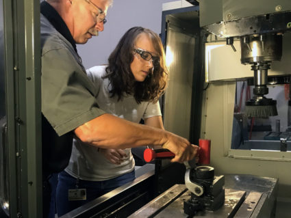 Gateway Technical College instructor Neil Petersen shows Rachel, an inmate at the Robert Ellsworth Correctional Facility in Wisconsin, how to properly load a computer numerical control machine. Photo by Mary Jo Brooks