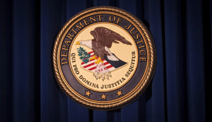 The Department of Justice (DOJ) logo is pictured on a wall after a news conference in New York December 5, 2013. Photo by REUTERS/Carlo Allegri